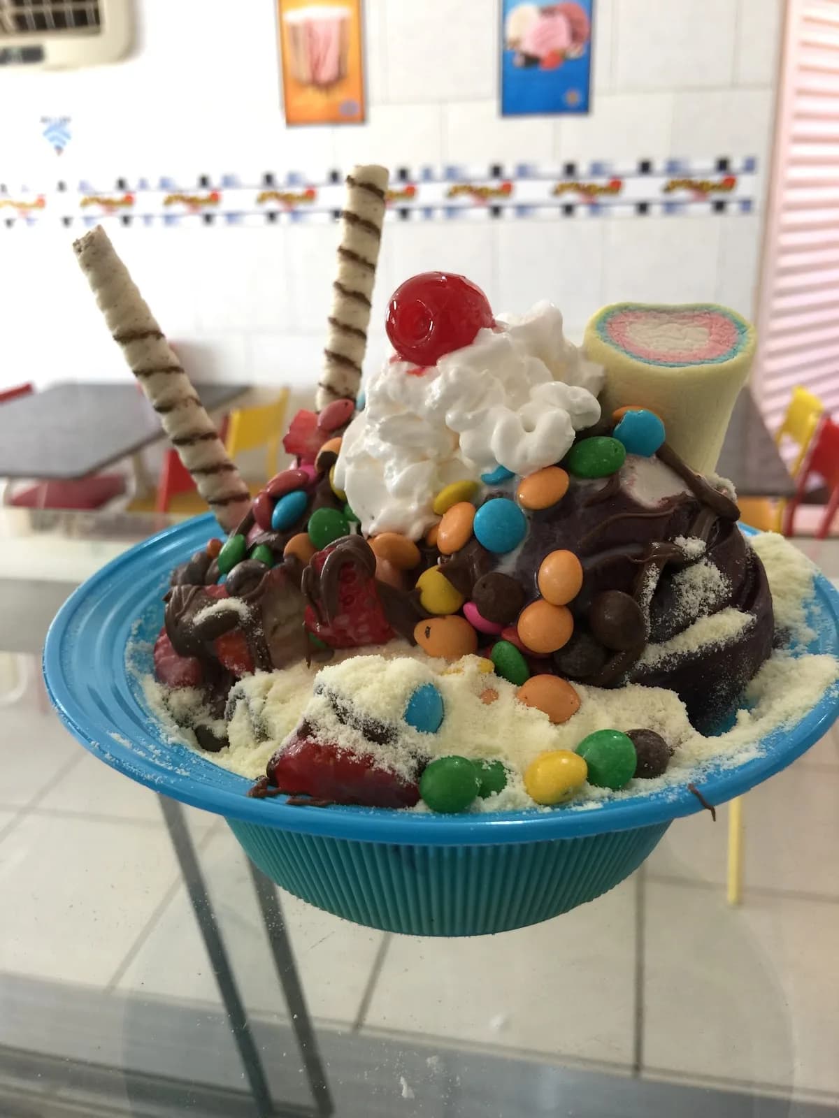 Tigela de açaí da Skibom coberta de chantilly, cereja, confeitos e wafer
